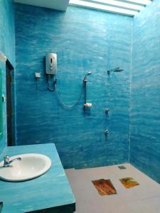 baño con lavabo y pared azul en White Villa Goyambokka en Tangalle