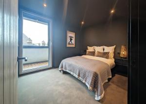 a bedroom with a bed and a large window at The Bells - Luxury Serviced Apartments in Leeds