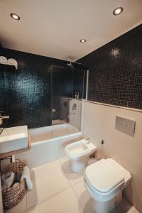 a bathroom with a toilet and a sink and a tub at Mansión Botánico Luxury Buenos Aires in Buenos Aires