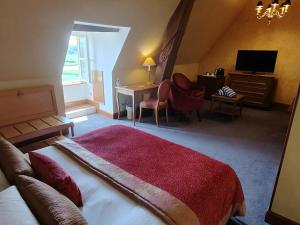 um quarto com uma cama, uma secretária e uma televisão em Hôtel Golf Château de Chailly em Chailly-sur-Armançon