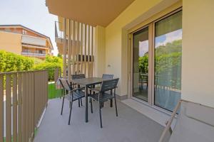 balcone con tavolo nero e sedie. di ApartmentsGarda - Residenza Eleonora a Garda