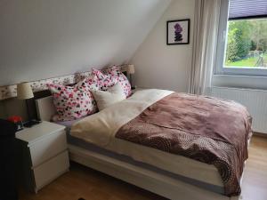 a bedroom with a bed with pillows and a window at Ferienwohnung am Allerbogen in Neu Wietze