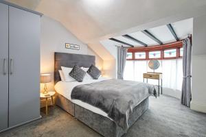 ein Schlafzimmer mit einem großen Bett und einigen Fenstern in der Unterkunft Apartment 4, Khyber Lodge Apartment Whitby in Whitby