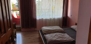two beds sitting in a room with a window at Family Villa Sarapin in Kretinga