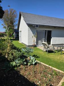 a house with a bench in the yard at Airport Fresh Lodge in Boksburg