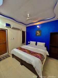 Un dormitorio con una pared azul y una cama en Hotel Amazing Jaisalmer, en Jaisalmer