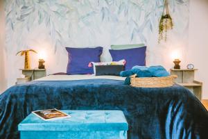 1 dormitorio con 1 cama grande y edredón azul en La Grange de Cablanc en Monestier