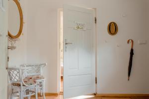 a white door in a room with a table and an umbrella at Villa Kurorto Namas in Druskininkai