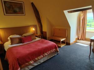 a bedroom with a bed with a red blanket and a window at H&ocirc;tel Golf Ch&acirc;teau de Chailly in Chailly-sur-Arman&ccedil;on