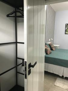 a room with a bed and a door leading to a bedroom at Naturaleza in Morretes +1 photo