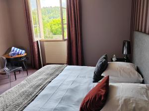 um quarto com uma cama com almofadas e uma janela em Hôtel Golf Château de Chailly em Chailly-sur-Armançon