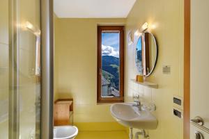 un bagno con un lavandino, uno specchio e una finestra di Al Cargá San Vigilio di Marebbe a San Vigilio Di Marebbe Altre 39 foto