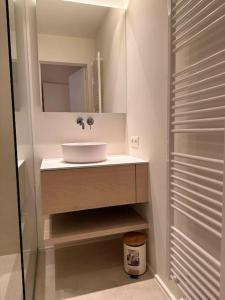 a bathroom with a sink and a mirror at Knokke Oasis Luxury Apartment in Centre in Knokke-Heist