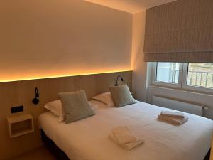 a bedroom with a large white bed with two pillows at Knokke Oasis Luxury Apartment in Centre in Knokke-Heist
