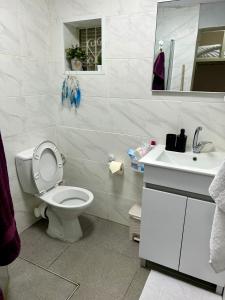 biała łazienka z toaletą i umywalką w obiekcie Heart of the City w mieście Riszon le-Cijjon