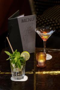 a table with a drink and a book and a martini at Best Western Plus Monopole M&eacute;tropole in Strasbourg