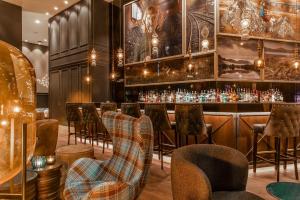 グラスゴーにあるMotel One Glasgowのスツールの並ぶバーとバーカウンター