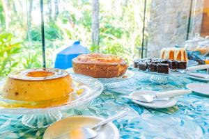 een tafel met gebak en desserts op borden bij VELINN Feiticeira Praia Hotel in Ilhabela