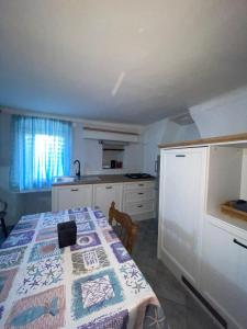 a kitchen with a table with a quilt on it at Apartment Kalikut in Beli