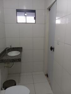 a white bathroom with a toilet and a sink at Hotel Lajeado in Lajeado