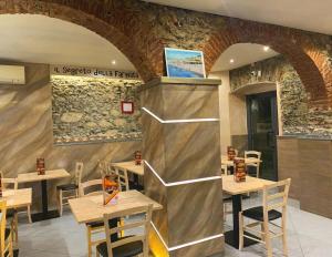a restaurant with wooden tables and a stone wall at Lovely homes in Genoa