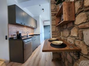 uma cozinha com uma mesa de madeira e uma parede de pedra em Sera Homes Kaleici Oldtown em Antália