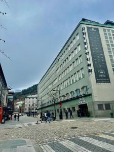 un gran edificio con gente caminando delante de él en Magic Hotel Xhibition, en Bergen