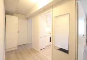 an empty room with a door and a mirror at Forenom Serviced Apartments Hämeenlinna Katuma 1 in Hämeenlinna