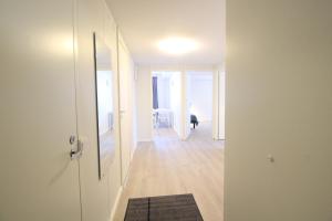 a hallway with a white door and a room with a table at Forenom Serviced Apartments Hämeenlinna Katuma 1 in Hämeenlinna
