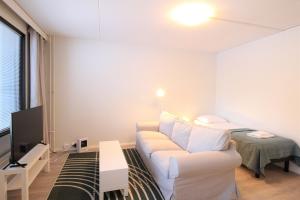 a living room with a white couch and a bed at Forenom Serviced Apartments Hämeenlinna Katuma 1 in Hämeenlinna +44 photos
