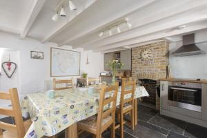 une cuisine et une salle à manger avec une table et des chaises dans l'établissement Dolor Cottage, à Coverack