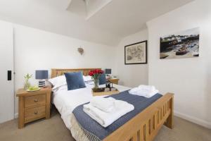 une chambre avec un grand lit avec des serviettes dessus dans l'établissement Dolor Cottage, à Coverack