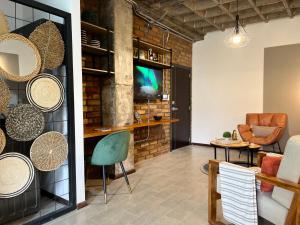a living room with a brick wall and chairs at Tinta & hierro suite 1 in Loja