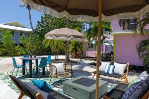 a patio with a table and chairs and an umbrella at Charming Suite with Balcony and Bikes in Historic Sandpiper Inn in Sanibel