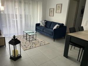 un salon avec un canapé bleu et une table dans l'établissement le Natural, à Thonon-les-Bains