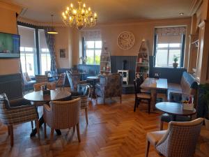 a restaurant with tables and chairs and a chandelier at Ye Olde Fighting Cocks in Arnside