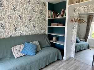 a living room with a couch and a book shelf at Le Ronsard in Blye