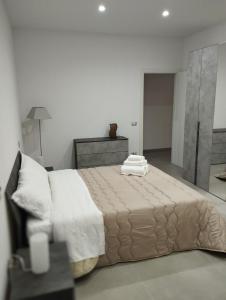 a bedroom with a large bed with towels on it at Be Home in Matera