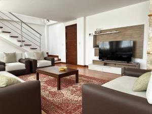 uma sala de estar com um sofá e uma televisão em Instant Hotel - Villa Palermo Luxury Apartments em Ambato
