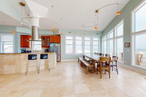 a kitchen with a table and chairs and windows at Boundless Horizons in Surf City