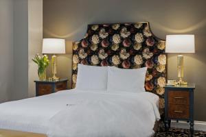 a bedroom with a white bed with two nightstands and two lamps at Inn at the Opera in San Francisco