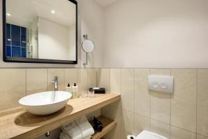 uma casa de banho com um lavatório e um espelho em June Six Hotel Hannover City em Hanôver