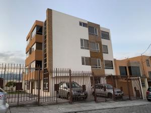 ein Gebäude mit davor geparkt in der Unterkunft Instant Hotel - Villa Palermo Luxury Apartments in Ambato