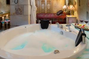 a bath tub filled with water in a bathroom at Cappadocia Acer Cave Hotel in Ortahisar +48 photos
