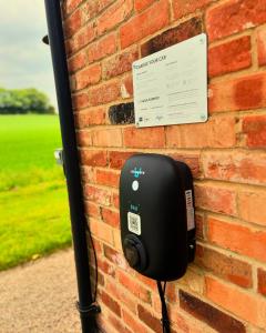 telefon jest przymocowany do ściany z cegły w obiekcie Cosy One Bed Barn Conversion Donington Park East Midlands Airport w mieście Derby