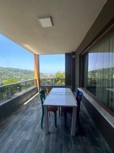 a room with a table and chairs on a balcony at De&Ne apart 2 in Rize