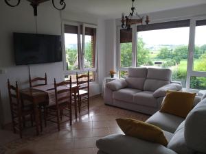 a living room with a couch and a table at Casa Cabarceno Piscina y Barbacoa in Bofetán