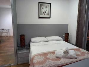 Un dormitorio con una cama con una toalla encima. en Book Santos - Unlimited 1910 - Tranquilidade Vista Mar, en Santos