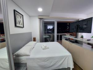 Un dormitorio con una cama blanca y una ventana. en Book Santos - Unlimited 1910 - Tranquilidade Vista Mar, en Santos