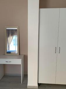 a mirror sitting on a table next to a white cabinet at Meri Hause in Vlorë +1 photo